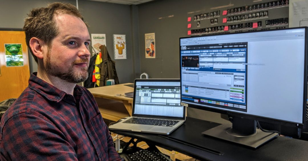 Photo of a man in an office, in front of a laptop and large monitor. The photo is for an article about 50 ways to use FileMaker.