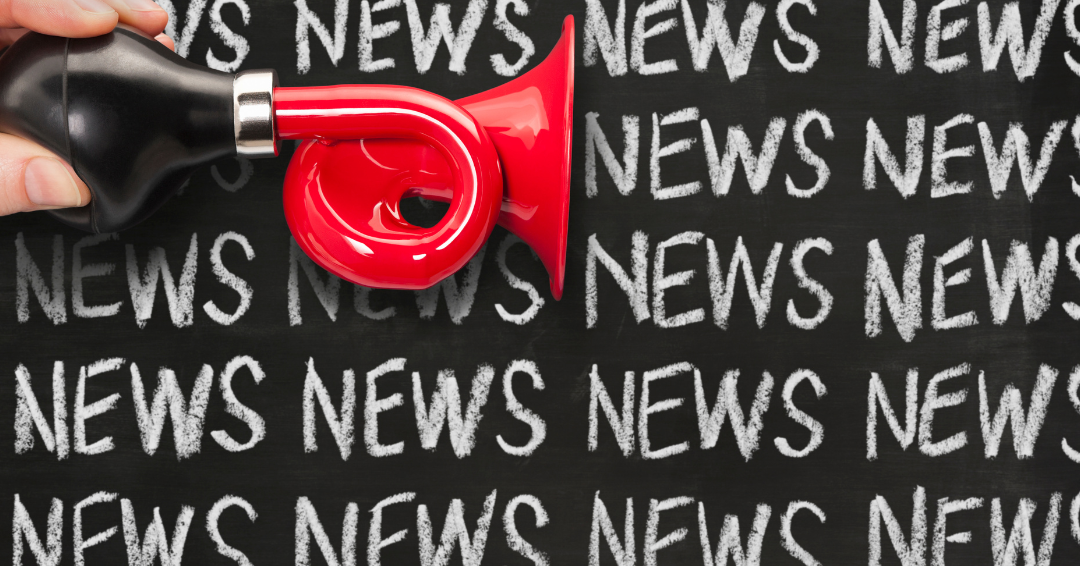 Photo of a miniature red bike horn, overlaid across a blackboard background, with the word News in white, repeating across the backdrop.